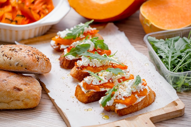 Bruschetta de chapata a la parrilla con calabaza al horno, rúcula feta y especias. bocadillo saludable de calabaza al horno de otoño