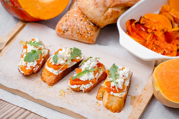 Bruschetta de chapata a la parrilla con calabaza al horno, rúcula feta y especias. bocadillo saludable de calabaza al horno de otoño