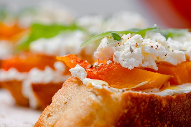 Bruschetta de chapata a la parrilla con calabaza al horno, rúcula feta y especias. bocadillo saludable de calabaza al horno de otoño