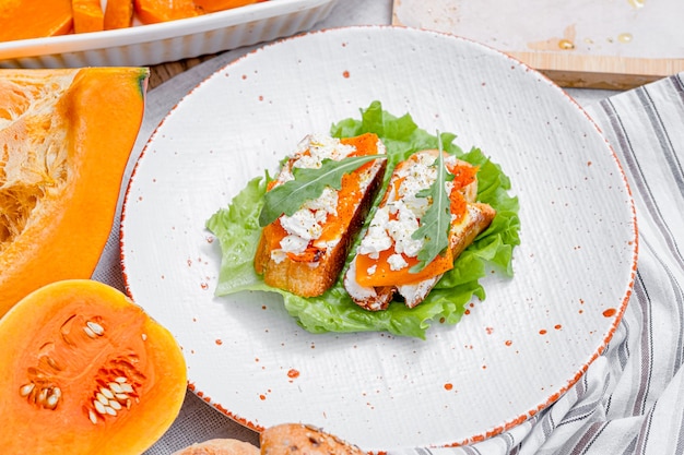 Bruschetta de chapata a la parrilla con calabaza al horno, rúcula feta y especias. bocadillo saludable de calabaza al horno de otoño