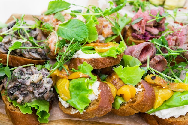 Bruschetta com cogumelos e queijo e ervas bruschetta com pimenta preta e ricota bruschetta com rosbife e marmelada de cebola azul Foto horizontal