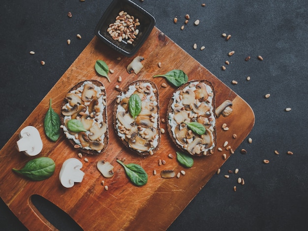 Bruschetta com cogumelos, espinafre, alho, cream cheese e pinhões