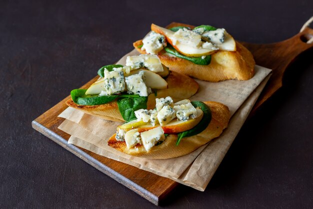 Bruschetta com espinafre, pêra e queijo azul. Vinho. Comida vegetariana. Alimentação saudável. Veganismo. Dieta.