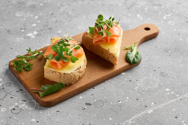 Bruschetta com salmão. pão integral com salmão e queijo em uma tábua de madeira