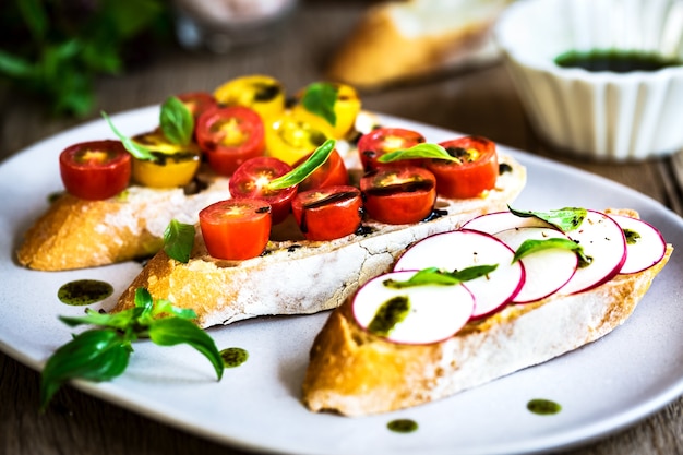 Bruschetta com tomate cereja e rabanete com óleo de manjericão,