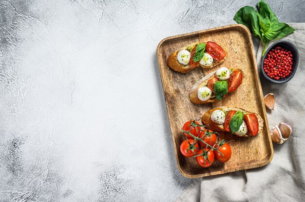 Bruschetta com tomate, queijo mussarela e manjericão