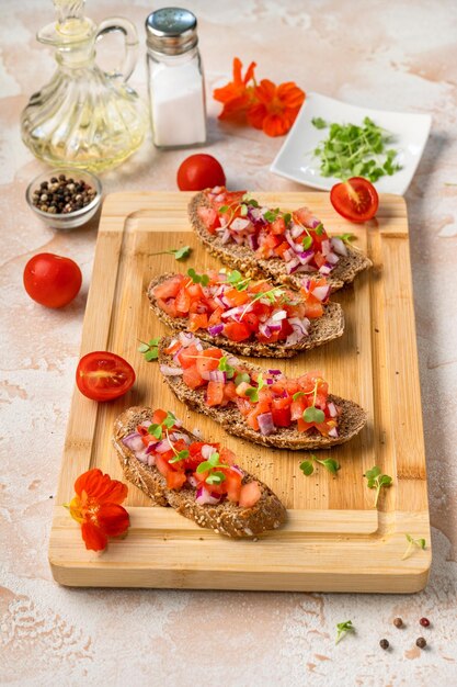 Bruschetta com tomates e cebola em tábua de madeira