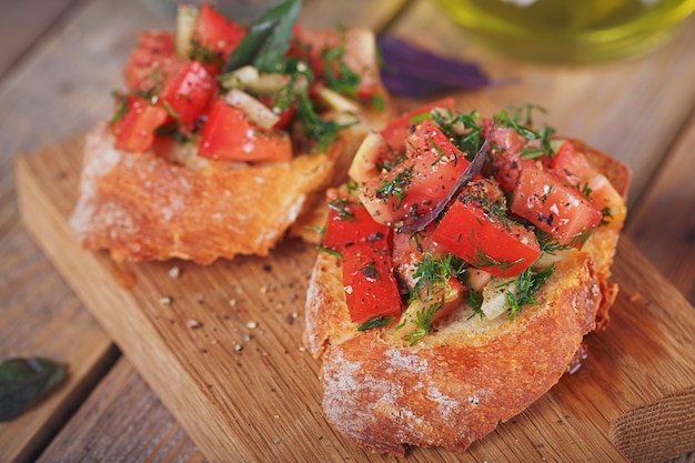 Bruschetta com tomates, manjericão e ervas picados no pão duro grelhado.