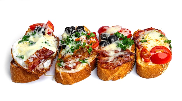 Foto bruschetta con diferentes rellenos sobre un fondo blanco. bruschetta de verduras, carne y queso. foto de alta calidad