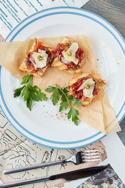 Bruschetta em uma mesa de madeira em um prato branco e uma taça de vinho tinto