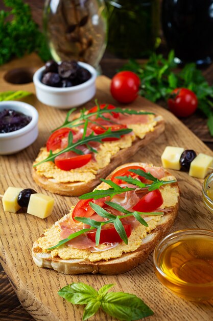 Bruschetta grelhada com rillettes de frango, jamon e ervas. Deliciosa torrada com patê de frango e petiscos diversos