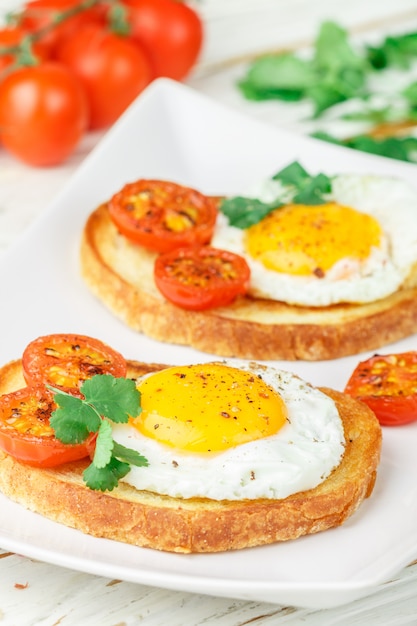 Bruschetta con huevo frito, tomate y hierbas.