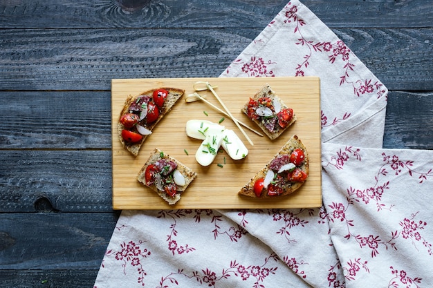 Bruschetta italiana hecha con rebanadas de pan tostado con tomates cherry