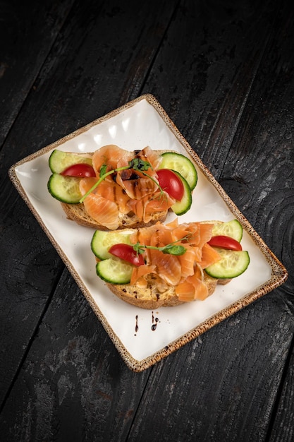 Bruschetta con mariscos y verduras en un plato blanco.