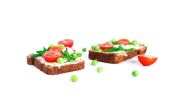Bruschetta mit Frischkäse und Gemüse auf einem weißen Hintergrund. Toasts isoliert. Sandwich isoliert. Sandwich mit Gemüse und Käse. Foto in hoher Qualität