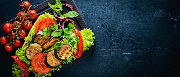 Bruschetta mit gegrilltem Gemüse Oliven Kräuter und Parmesan-Käse auf Brot Kalte Snacks italienische Küche auf hölzernen Hintergrund