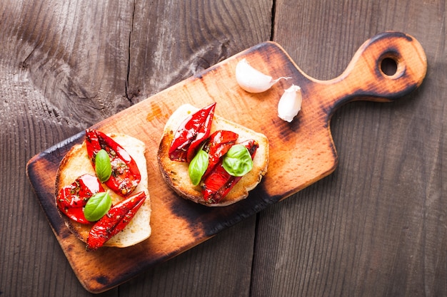 Bruschetta mit getrockneten Tomaten, Basilikumblättern und Knoblauch