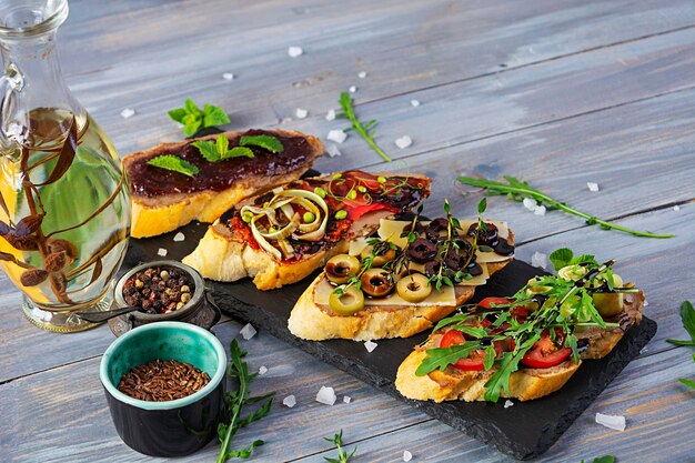 Foto bruschetta mit hühnerleberpaste köstliche bruschettas mit verschiedenen füllungen verschiedene bruschetta auf holzgrund