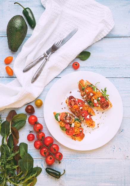 Bruschetta mit Käse, Basilikum, Rucola und Cherrytomaten