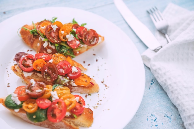 Bruschetta mit Käse, Basilikum, Rucola und Cherrytomaten