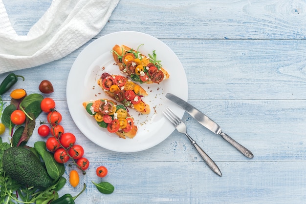 Bruschetta mit Käse, Basilikum, Rucola und Cherrytomaten