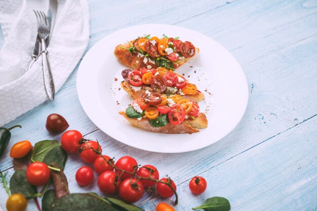 Bruschetta mit Käse, Basilikum, Rucola und Cherrytomaten