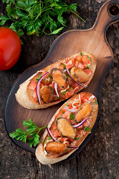 Bruschetta mit Muscheln, Käse und Tomaten