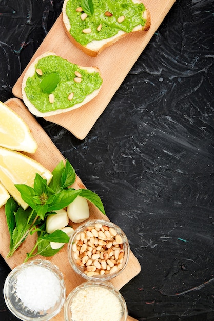 Bruschetta mit Pesto-Sauce, Parmesan und frischem Basilikum