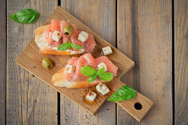 Bruschetta mit Räucherlachs, Frischkäse, Oliven und Rucola