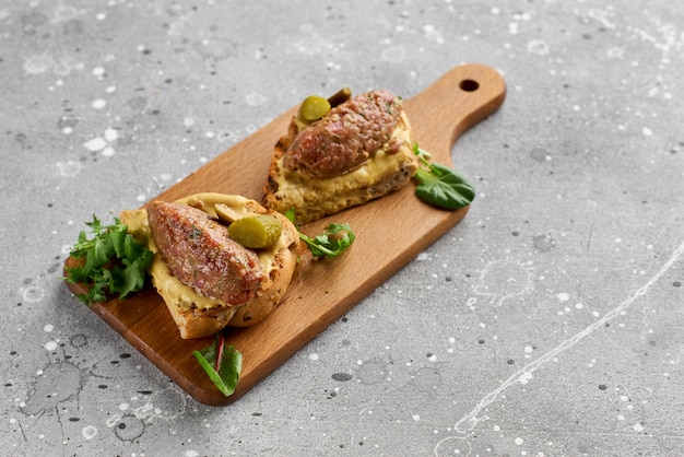 Foto bruschetta mit rindertartar auf einem holzbrett. gesunder, leckerer, nahrhafter snack