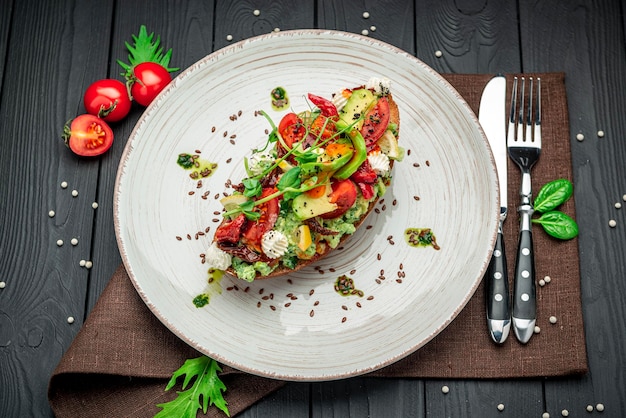 Bruschetta mit sonnengetrockneten Tomaten, Frischkäse, Avocado und frischem Gemüse