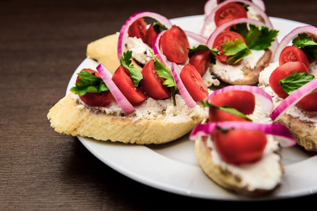 Bruschetta mit Tomaten, Käse, Zwiebeln und Petersilie