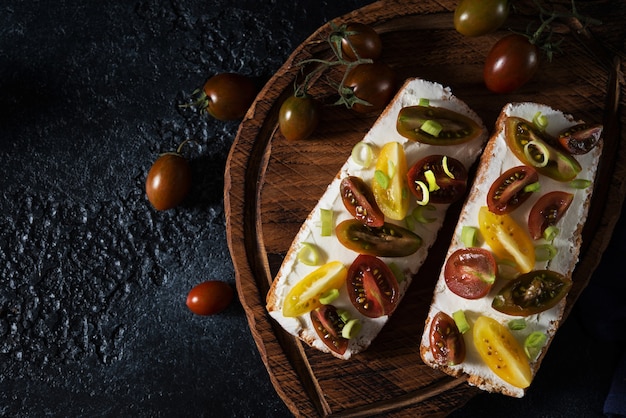 Bruschetta mit Tomaten und Olivenöl auf einem Holzbrett - traditioneller italienischer, spanischer Snack, selektiver Fokus