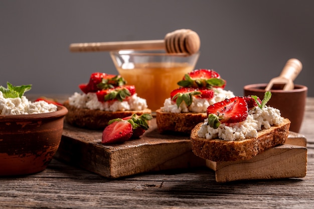 Bruschetta mit Vollkornbrot, Hüttenkäse Ricotta, Honig, Chia, Erdbeere, Kopierraum. Sommermenü Catering