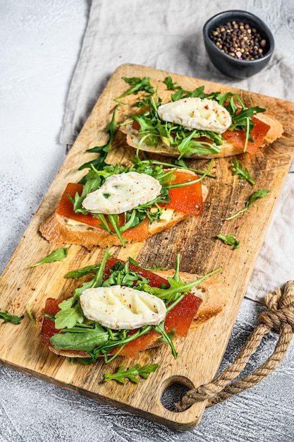 Bruschetta mit Ziegenkäse, Rucola und Birnenmarmelade. Graue Oberfläche. Draufsicht