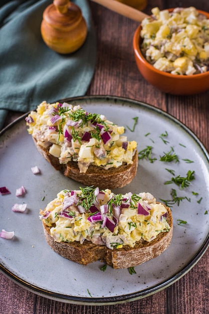 Bruschetta no pão de centeio com salada sueca em um prato na mesa vertical