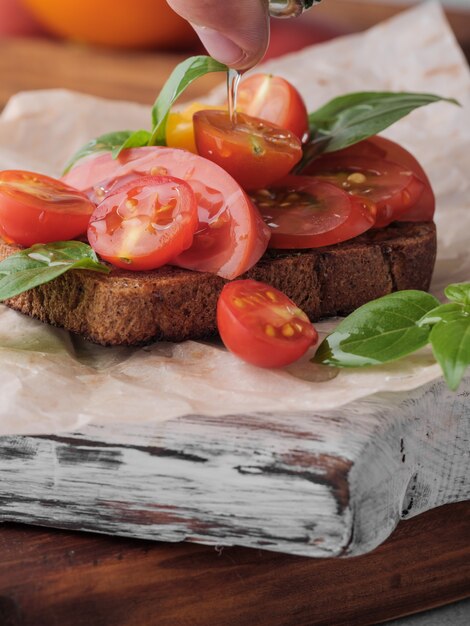 Bruschetta no pão preto com tomate e manjericão.