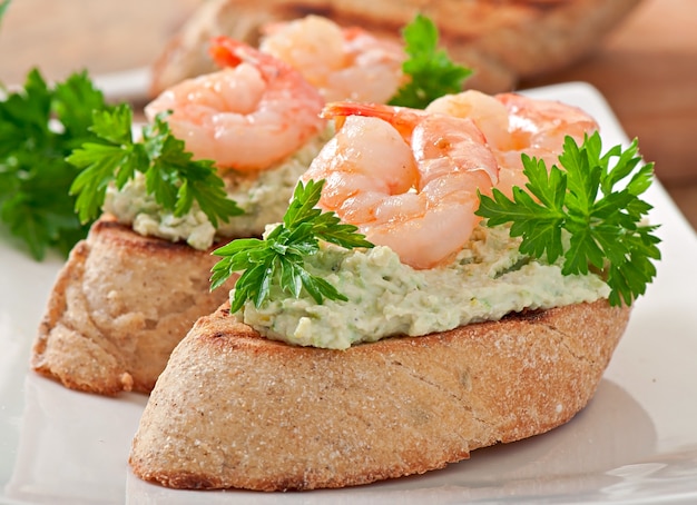 Bruschetta con una pasta de guisantes y camarones