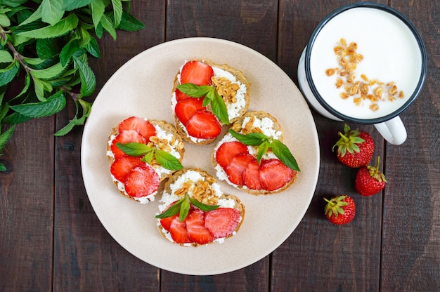 Bruschetta pequeña con cuajada y fresas frescas con menta