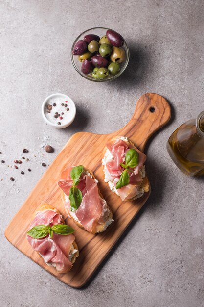 Bruschetta con prosciutto albahaca aceitunas especias y hierbas Aperitivos