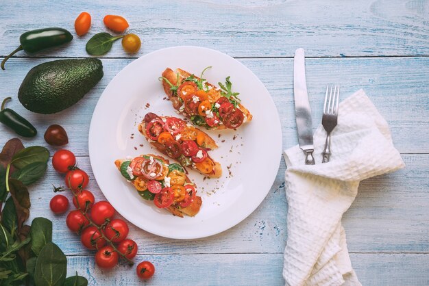 Bruschetta con queso, albahaca, rúcula y tomates cherry