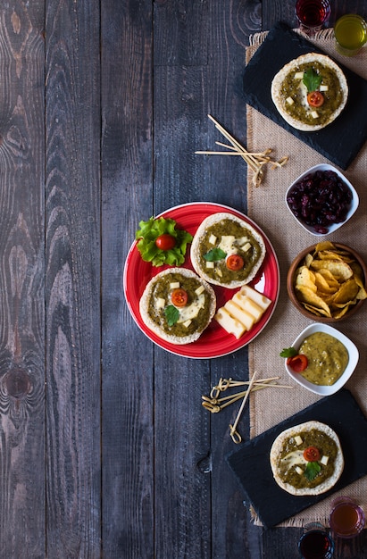 Bruschetta sabrosa y deliciosa con aguacate, tomate, queso, hierbas, papas fritas y licor.