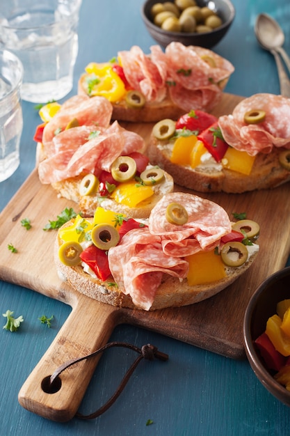 Bruschetta de salami con pimientos asados aceitunas de queso de cabra