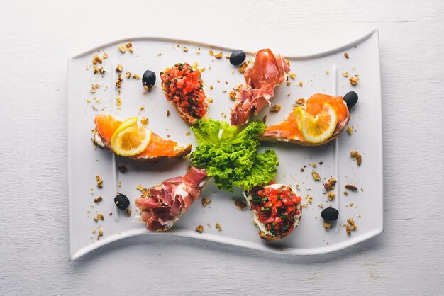 Bruschetta-Sandwich mit Lachs und Hamoon Auf einem hölzernen Hintergrund Ansicht von oben Freier Speicherplatz