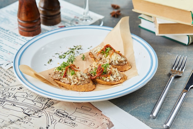 Bruschetta sobre una mesa de madera en una placa blanca.