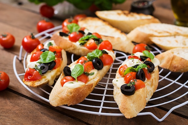 Bruschetta con tomate, mozzarella, aceitunas y pesto de albahaca