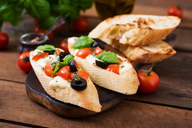 Bruschetta con tomate, mozzarella, aceitunas y pesto de albahaca