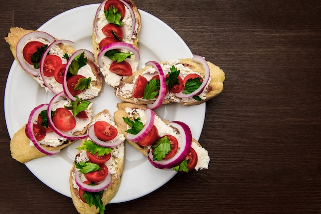 Bruschetta con tomate, queso, cebolla y perejil