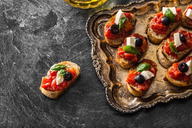 Bruschetta tostada con tomates mozzarella aceitunas albahaca y aceite de oliva cocina italiana