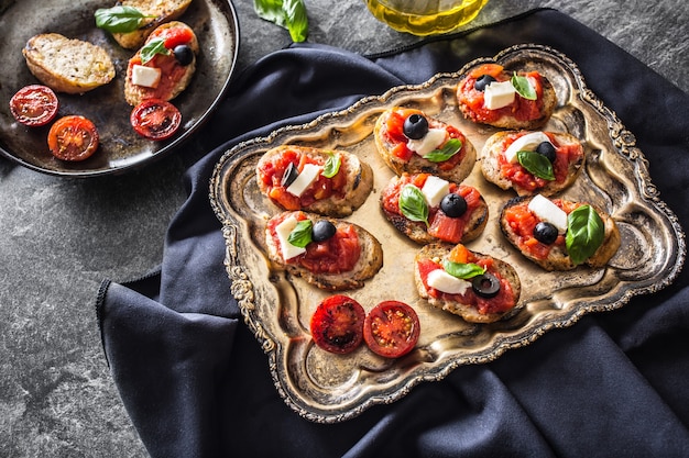 Bruschetta tostada con tomates mozzarella aceitunas albahaca y aceite de oliva cocina italiana